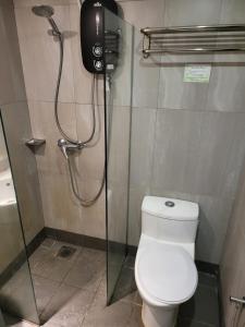 a bathroom with a shower with a toilet and a phone at Avaria KL in Kuala Lumpur
