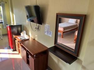 a room with a mirror and a table and a bed at V Tharm Hotel in Udon Thani
