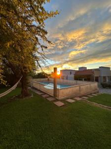 un patio trasero con piscina y un árbol en Villa Bonita Cabañas en Merlo