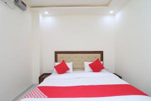 a bedroom with a bed with red and white pillows at OYO Hotel Dezzire in Ballabgarh