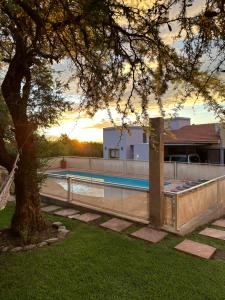 a swimming pool in a yard with a tree at Villa Bonita Cabañas Villa de Merlo in Merlo