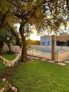 una hamaca colgada de un árbol junto a una piscina en Villa Bonita Cabañas en Merlo
