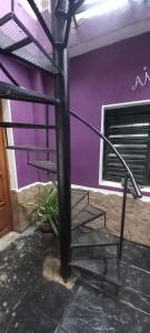 a spiral staircase in a house with a purple wall at Los Cactus Planta Alta in La Rioja