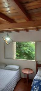 sypialnia z 2 łóżkami i oknem w obiekcie Los Cactus Planta Alta w mieście La Rioja