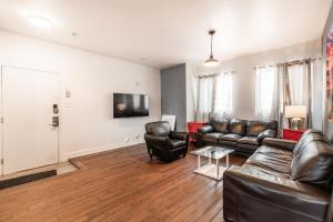 een woonkamer met lederen meubels en een flatscreen-tv bij Appartement 3 chambres - 2234 in Montreal