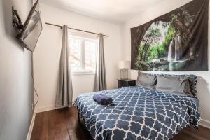 een slaapkamer met een bed en een schilderij aan de muur bij Appartement 3 chambres - 2234 in Montreal