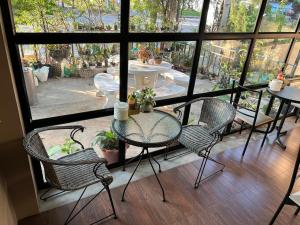 balcón con mesa y sillas y patio en V Tharm Hotel, en Udon Thani
