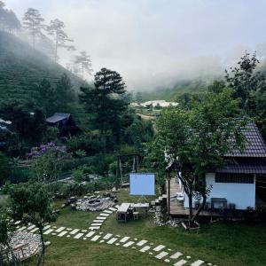 a view of a garden with a house and a screen at Đồi Lát Homestay in Ấp An Kroët