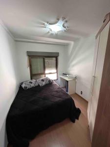 Schlafzimmer mit einem Bett und einem Deckenventilator in der Unterkunft Apartamento Central COM 02 BOX de garagem in Caxias do Sul