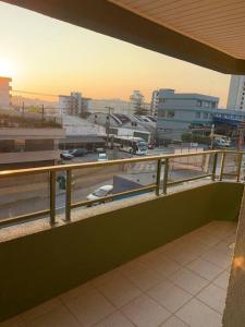 einen Balkon mit Blick auf eine Stadt mit Autos in der Unterkunft Apartamento Central COM 02 BOX de garagem in Caxias do Sul