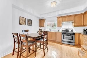 a kitchen with wooden cabinets and a table and chairs at Townhome by Subway and Downtown Toronto in Greektown in Toronto