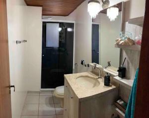 ein Bad mit einem Waschbecken, einem WC und einer Dusche in der Unterkunft Apartamento Central COM 02 BOX de garagem in Caxias do Sul