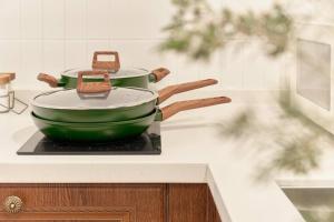 two green pots and pans sitting on a stove at Preesh house in Seoul
