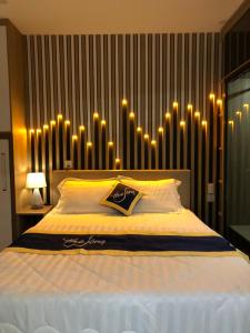 una camera da letto con un grande letto con luci sul muro di CONDOTEL 5 SAO THE SÓNG VŨNG TÀU Mr VƯƠNG a Vung Tau