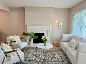ein Wohnzimmer mit einer weißen Couch und einem Kamin in der Unterkunft New remol modern tranquil house near SFO in San Mateo