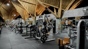 a gym with rows of treadmills and weights at Kalea Villas in Kuta Lombok
