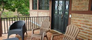 two chairs sitting on a porch next to a door at Apartamento Concepción de Ataco, Los Tablones in Ahuachapán