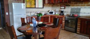 uma cozinha com uma mesa e um frigorífico branco em Apartamento Concepción de Ataco, Los Tablones em Ahuachapán