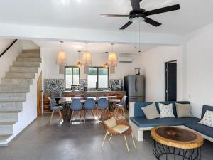 Casa Naay في جزيرة هول بوكس: غرفة معيشة مع أريكة زرقاء ومطبخ