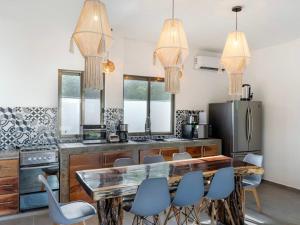 a kitchen with a wooden table and blue chairs at Casa Naay in Holbox Island