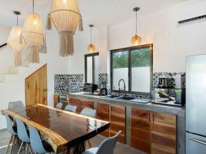 a kitchen with a wooden table and a counter top at Casa Naay in Holbox Island