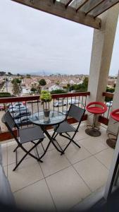 a patio with a glass table and chairs on a balcony at Excelente depto equipado completo, a pasos del mar in La Serena