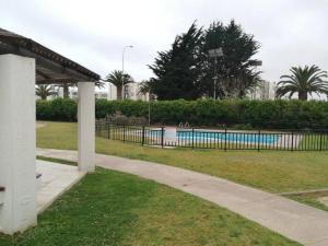 a swimming pool in a park with a fence at Excelente depto equipado completo, a pasos del mar in La Serena