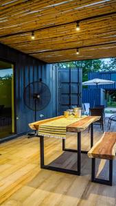 a large wooden table on a deck with benches at Container Lodge SB in San Bernardino