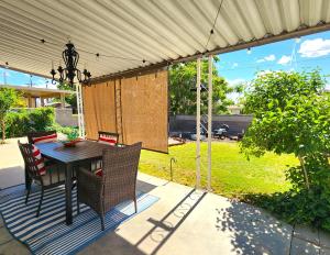 a patio with a table and chairs under a canopy at UPtown. UPscale. UPgraded. 3bd/2ba +Garage & Yard! in Albuquerque