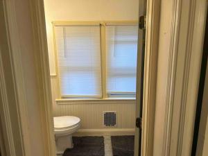 La salle de bains est pourvue de toilettes et d'une fenêtre. dans l'établissement Comfortable Two-bedroom home, à Wilmington