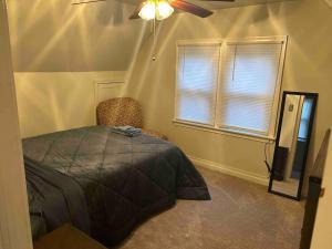 een slaapkamer met een bed, een ventilator en een raam bij Comfortable Two-bedroom home in Wilmington