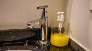 a bathroom sink with a bottle of soap and a soap dispenser at Container Lodge SB in San Bernardino