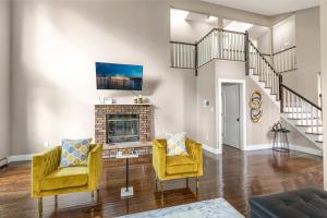 a living room with yellow chairs and a fireplace at Awesome Country Retreat - 5BR - Private & Peaceful in Monroe