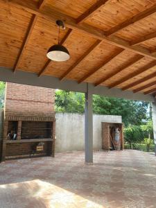 d'une terrasse avec une cheminée et un plafond en bois. dans l'établissement La Casa Del Lago, à Posadas