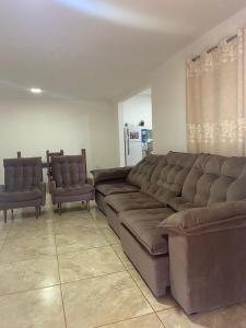 - un salon avec un grand canapé et deux chaises dans l'établissement La Casa Del Lago, à Posadas