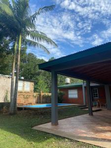 une maison avec un toit bleu et une piscine dans l'établissement La Casa Del Lago, à Posadas