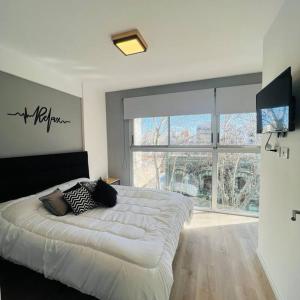 1 dormitorio con cama grande y ventana grande en Dúplex en Flores para 4 personas en Buenos Aires