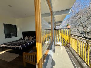 a bedroom with a bed on a balcony at Nomad Bed & Breakfast in Manāli