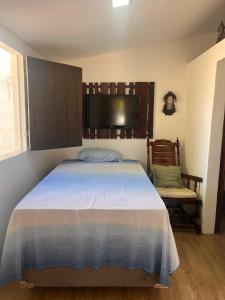 a bedroom with a large bed and a chair at Casa Encanto da Barra in Fortim