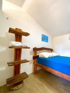 a bedroom with a bed and two wooden shelves at Casa Encanto da Barra in Fortim