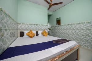 a bedroom with a bed with yellow and blue pillows at SPOT ON Hotel Ramgiri in Rāmtek