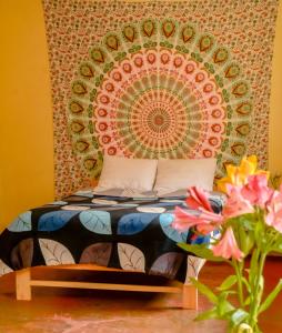 een bed in een kamer met een groot schilderij aan de muur bij Tayta Wasi Rent Pisac in Pisac