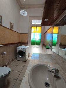 a bathroom with a tub and a washing machine at Hostal Tulio Porteño in Valparaíso