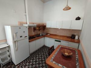 a kitchen with a table and a white refrigerator at Hostal Ekeka House in Valparaíso
