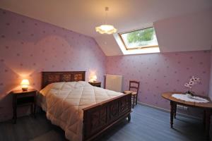 a bedroom with a bed and two tables and a window at Champblanc in Arnac-la-Poste