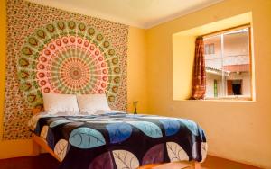 1 dormitorio con 1 cama con un mandala grande en la pared en Tayta Wasi Rent Pisac en Pisac