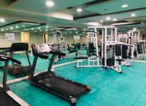 een fitnessruimte met verschillende loopbanden en machines bij Birch Tower a1 front of RobinsonMla Rizal Park in Manilla