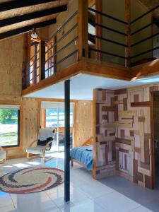 Habitación con pared de madera y cama. en Cabaña El Polux, ruta x-671, en Coyhaique