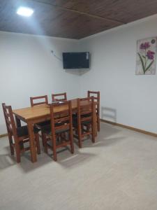 comedor con mesa de madera y sillas en CABAÑAS CHASCOMUS 2024 en Chascomús