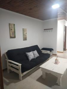 Sala de estar con sofá azul y mesa de centro en CABAÑAS CHASCOMUS 2024 en Chascomús
